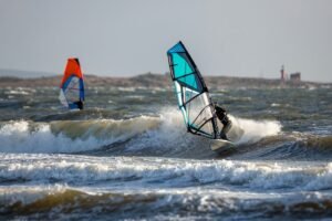 persons surfing on sea waves during daytime